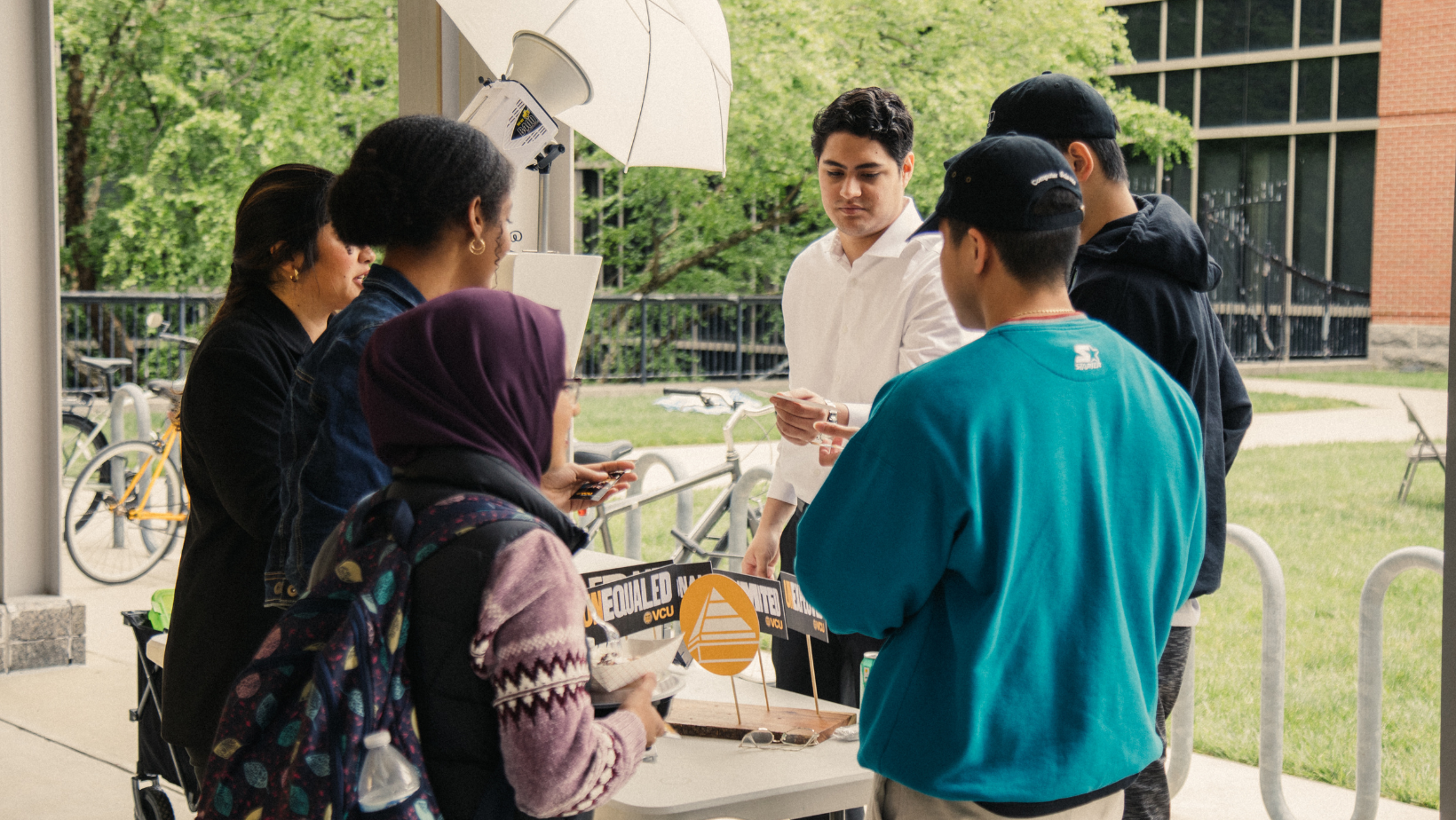 Students gathering outside near table